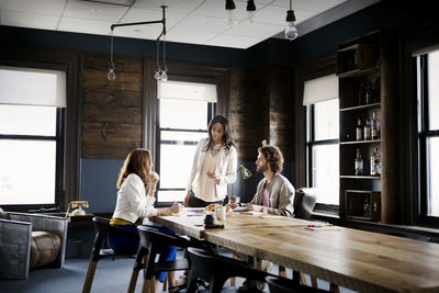 Business people discussing while sitting at desk in office