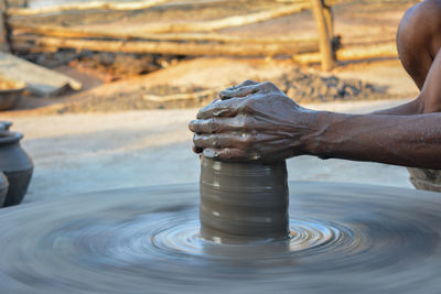 Close-up of hand working in mud