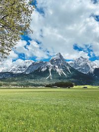 Scenic view of field and mountains against sky