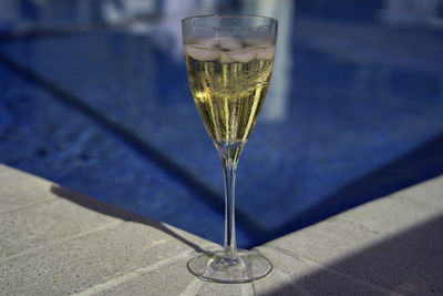 Close-up of wine champagne glass on pool