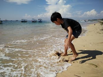 Side view of boy playing at shore
