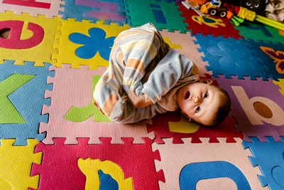 High angle view portrait of boy relaxing on bed