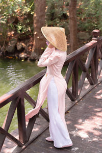 Rear view of woman wearing hat standing in city