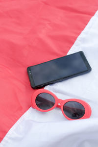 High angle view of sunglasses on mobile phone