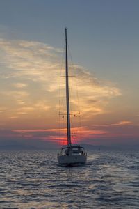 Boat sailing in sea at sunset