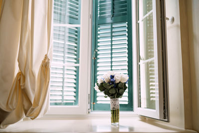 White flowers in vase on window sill