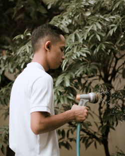 Full length of boy holding plant