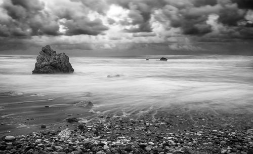 Scenic view of rocks in sea against sky