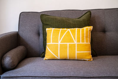 Close-up of yellow chair on sofa at home