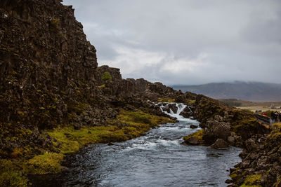 Scenic view of waterfall against sky