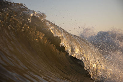 Close-up of waves splashing in sea against clear sky