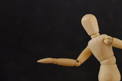 Wooden mannequin against black background