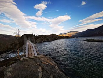 Scenic view of lake by mountains against sky