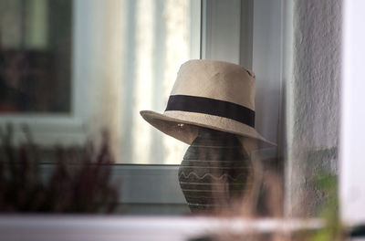 Reflection of hat on window at home