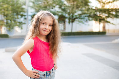 Portrait of smiling young woman standing in park