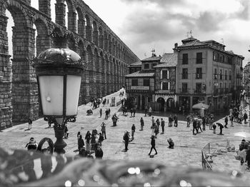 People on street against buildings in city