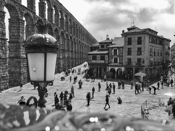 People on street against buildings in city