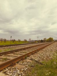 Railroad tracks on field against sky