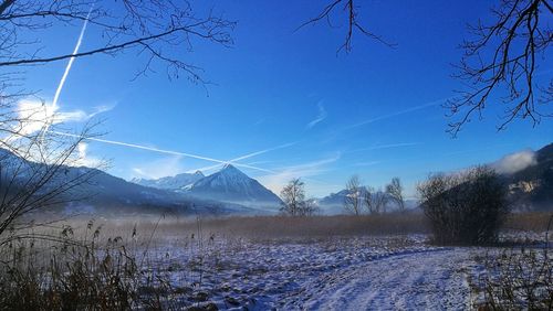 Scenic view of snow covered landscape against blue sky