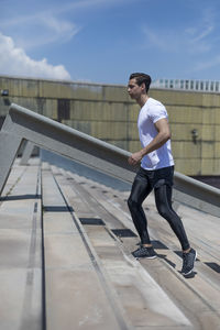 Full length of man climbing steps against sky