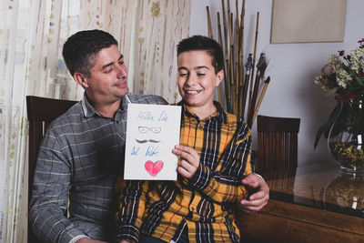 Young man smiling while holding smart phone