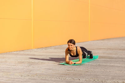 Young woman sitting on wall