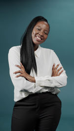 Smiling young woman against blue background
