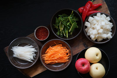 High angle view of chopped vegetables and apples on table
