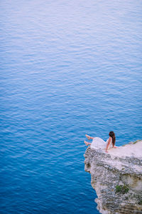 Rear view of a woman overlooking calm blue sea