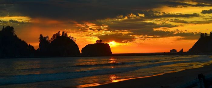Scenic view of sea against dramatic sky during sunset