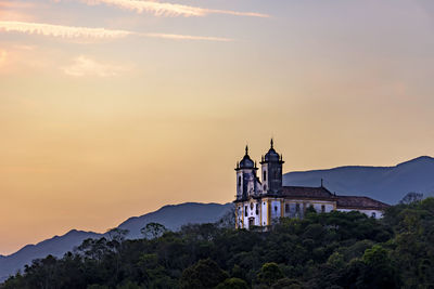 View of church and building against sky during sunset