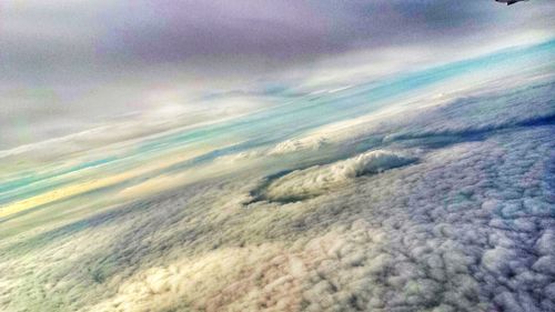 Aerial view of sea against cloudy sky