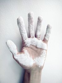Cropped image of dirty hand against wall