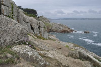 Rock formation on beach against sky