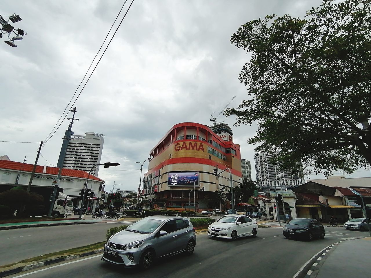 TRAFFIC ON ROAD BY BUILDINGS AGAINST SKY IN CITY