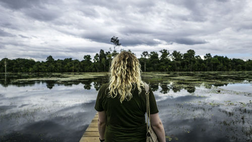 Rear view of man in lake against sky