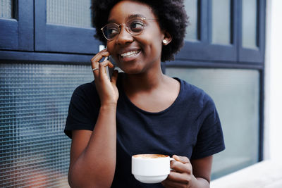 Portrait of a smiling young woman using mobile phone