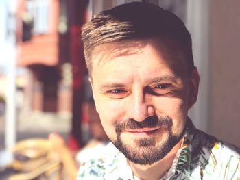 Close-up of thoughtful man smiling outdoors