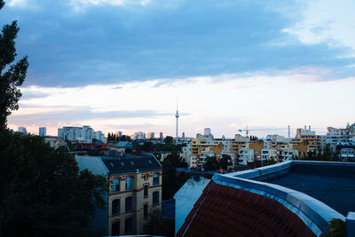 Distant view of fernsehturm in city against sky