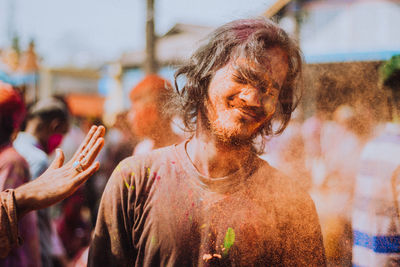 Portrait of young man with people in background