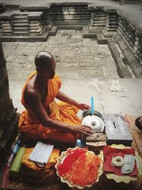 Man sitting in temple outside building