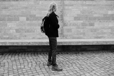 Full length side view of woman standing on footpath