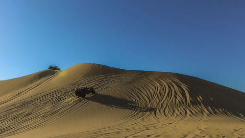 Scenic view of desert against clear blue sky