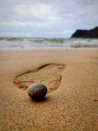 Close-up of stone on sand at beach