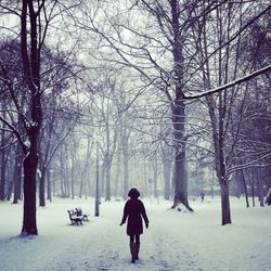 Woman walking on snow covered landscape