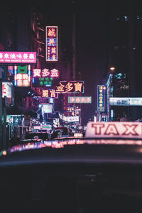 Illuminated restaurant by buildings in city at night