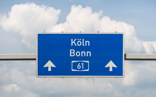 Low angle view of road sign against sky