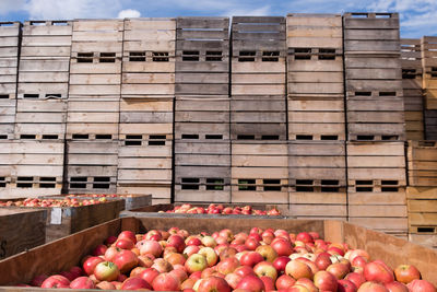 Stack of wooden apple crates with apples in foreground