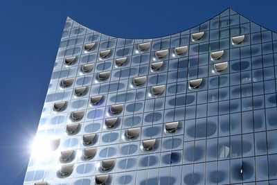 Low angle view of modern building against blue sky