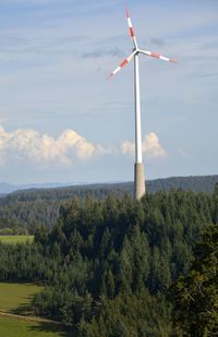 Windmill on field against sky